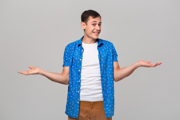Hesitant pretty man shrug shoulders having doubtful expressions