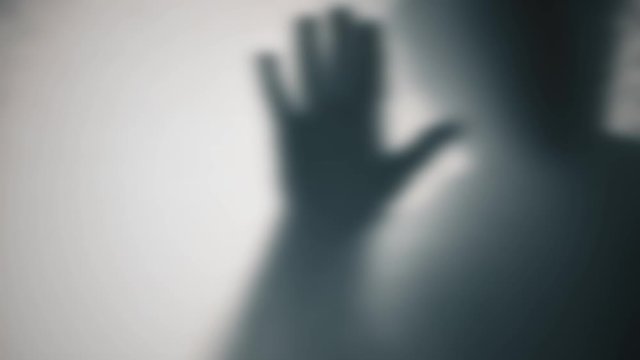 4K Blur silhouette man hands scratch glass, horror movie style with flashing light. trying to get inside room. Scary scene of nightmare. creepiness