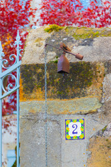 An ancient old doorbell at the mossy gates of an old French mansion. Chas, Auvergne, France.