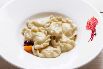 Homemade traditional Russian Ukrainian dumplings with cottage cheese on a white plate.