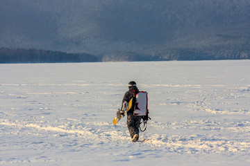 athlete snowboarder goes to the start in equipment and board. snowboarding is an extreme winter...