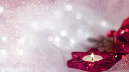 verträumte Weihnachtdekoration mit Kerze,  roten Kugeln und rotem Stern