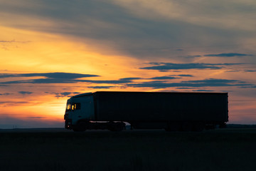 Truck on highway at sunset