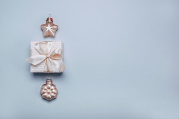 Christmas composition.Small gift box with Christmas decor a light blue background. Minimalism, flat lay. Copy space.