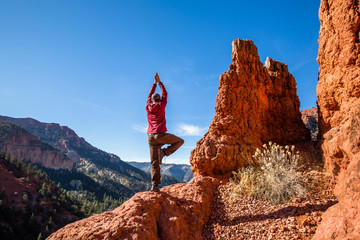 Yoga balance on red rock cliff edge in Southern Utah. Yoga in the wilderness.