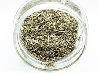 Green mint leaves in a bowl on white background.