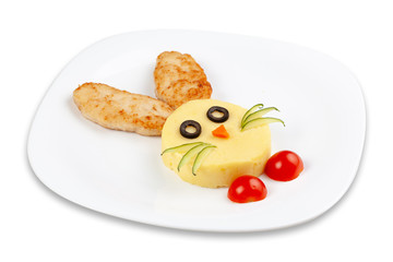 Chicken meatballs with mashed potatoes and tomatoes on a white plate. The dish is decorated in the...