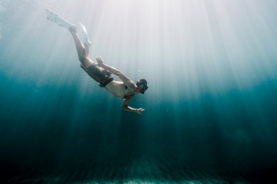 Side view of man swimming underwater in ocean