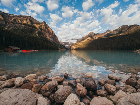 Lake Louise shoreline with boathouse and mountains in the distance.