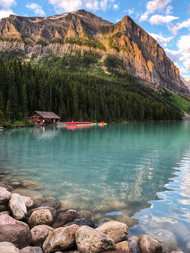 Lake Louise shoreline with boathouse and mountains in the distance.