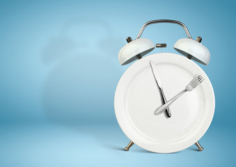 Concept of intermittent fasting, lunchtime, diet and weight loss. Plate as Alarm clock on blue