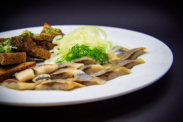 Croutons with herring on black background