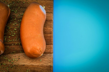 On a blue background on a wooden Board with spices are meat sausages