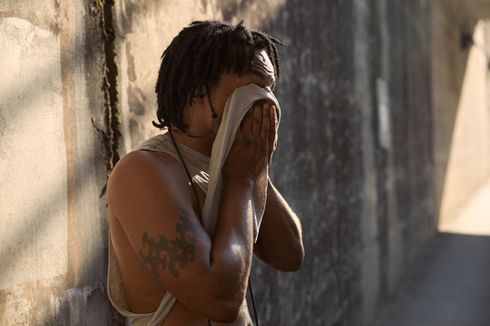 African-American wiping sweat from face