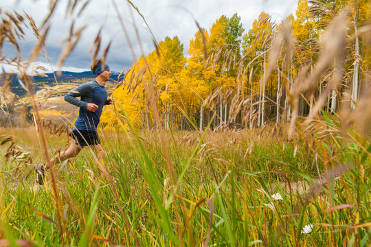 Man trail runs through meadow with fall color in Vail, Colorado