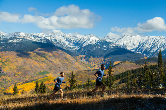 Men run ridge with Gore Range mountain views in Vail, Colorado