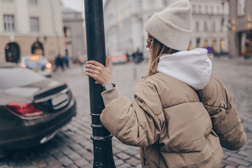 Beautiful young woman posing with watch in the street