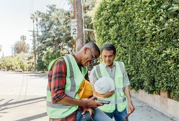 Municipal Workers Outside Look at Phone