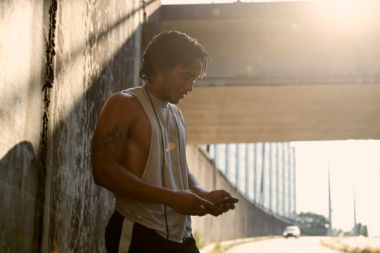 African-American man looking at phone after workout