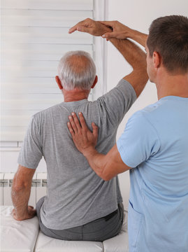 Chiropractic / Osteopathy treatment, Back pain relief. Physiotherapy for senior male patient, Kinesiology