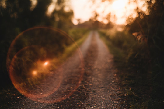 Sun Flare Bubble On Gravel Country Road  Leading to Sunset