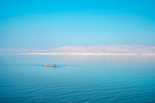 Man floating in the Dead Sea in early morning, Ein Bokek, Israel