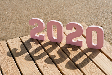 Creative inspiration concepts 2020 with text number and pink in color, with wooden background and...