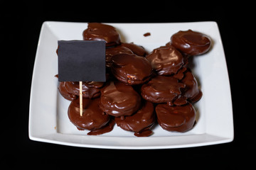 Chocolate covered snack cakes on a white dish. Delicious homemade cookies, a plate for signature.
