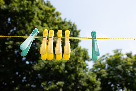 coloured pegs hanging on a washing line in an english country garden