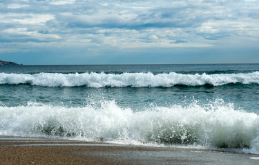 fantastic winter beach day with waves and clouds in the background