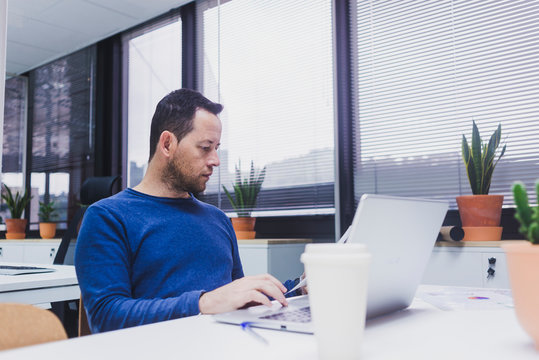 Bearded Man working on laptop in office