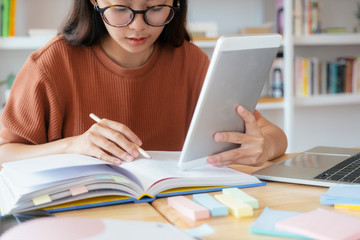 Young collage student using computer and mobile device studying