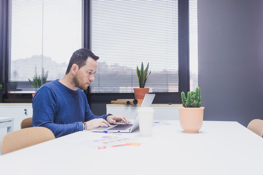 Bearded Man working on laptop in office