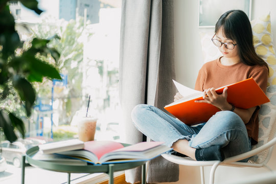 Collage student female reading and researching form book.