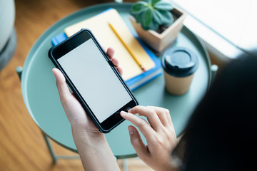 Closeup hands using smartphone mockup at the office desk.