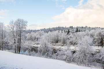 View to river Gauja in Gauja National Park with lot of snow and blue sky in December in Sigulda in Latvia