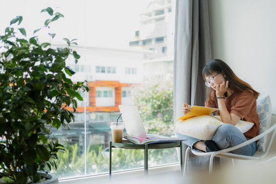Collage student female reading and researching form book.