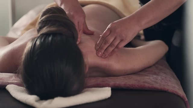 massage therapist works on lower body and hips of woman at the spa. lady relaxing with massage treatment at a luxury health & beauty spa. 4k 50 fps slow motion 
