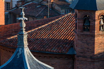 Decorative object and a bell tower in the middle of ceramic roofs in Toulouse