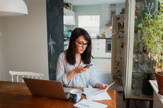 Woman using laptop and doing paper work