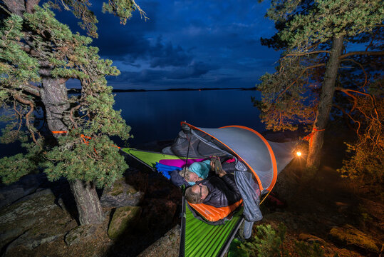 Man and woman sleeping in tent hanging on tree