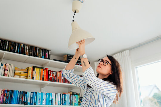 Woman fixing lamp