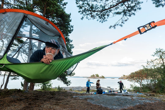 Man resting in hammock at lakeshore