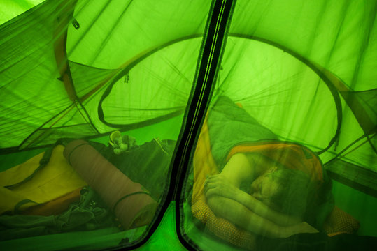 Man sleeping in green tent