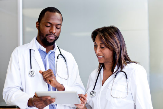 Two doctors going over reports on a tablet