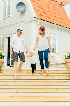 Baby boy with parents walking on steps