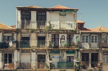 Old building with balconies, plants and hanging laundry in Porto - black and white