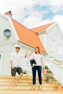 Baby boy with parents walking on steps