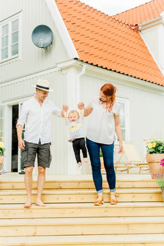 Baby boy with parents walking on steps