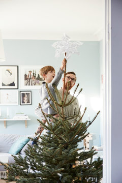 Father and son decorating Christmas tree